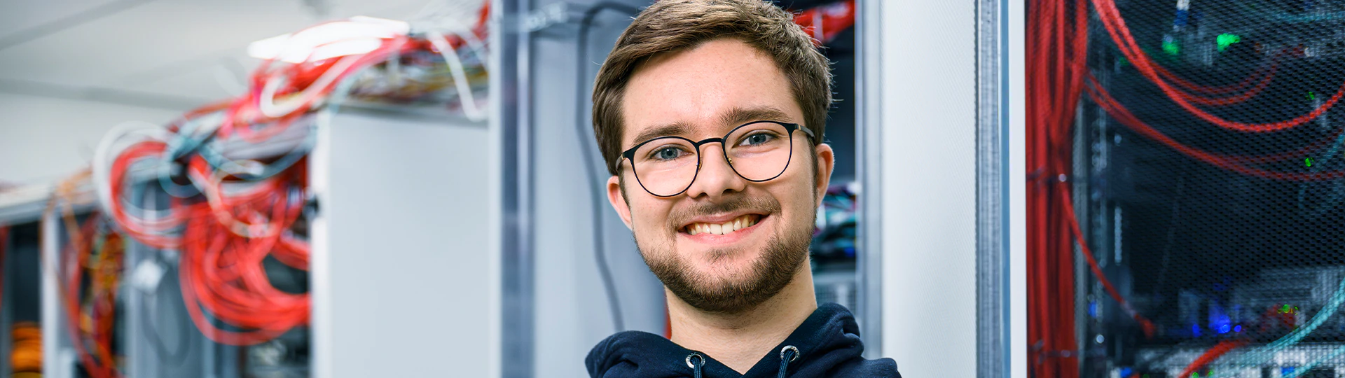 Junger Mitarbeiter der IT im Serverraum