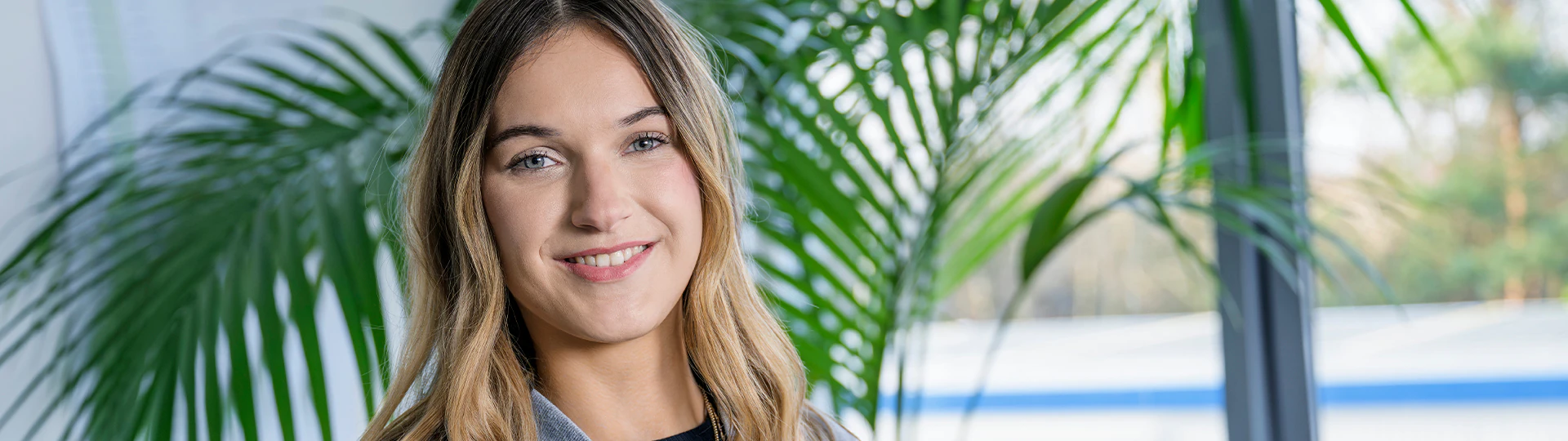 Praktikantin die am Arbeitsplatz lächelt